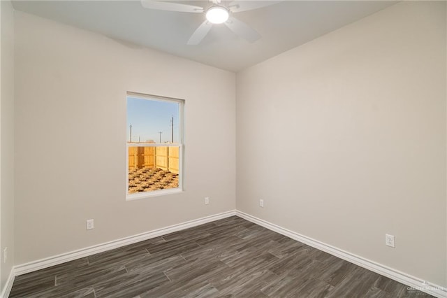 spare room with dark wood-type flooring, ceiling fan, and baseboards