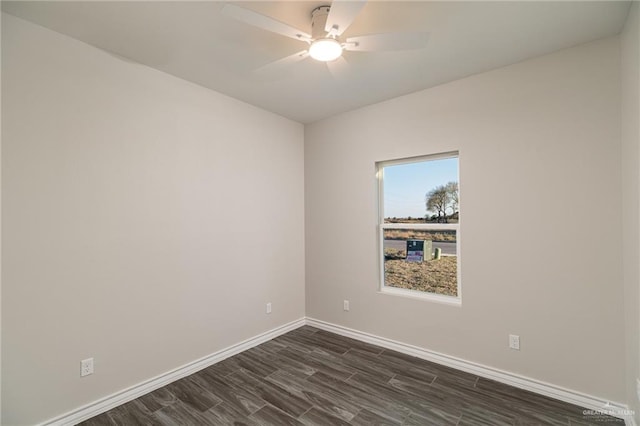 empty room with a ceiling fan, baseboards, and dark wood-type flooring