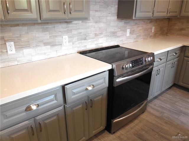 5421 San Diego Dr, Edinburg, TX 78542 - kitchen featuring stainless steel electric stove, gray cabinets, light countertops, tasteful backsplash, and wood finished floors