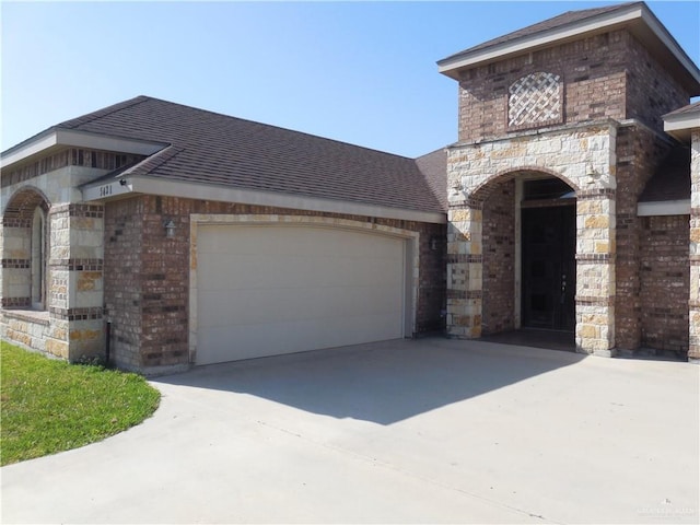 5421 San Diego Dr, Edinburg, TX 78542 - view of front facade with brick siding, concrete driveway, a garage, stone siding, and a shingled roof