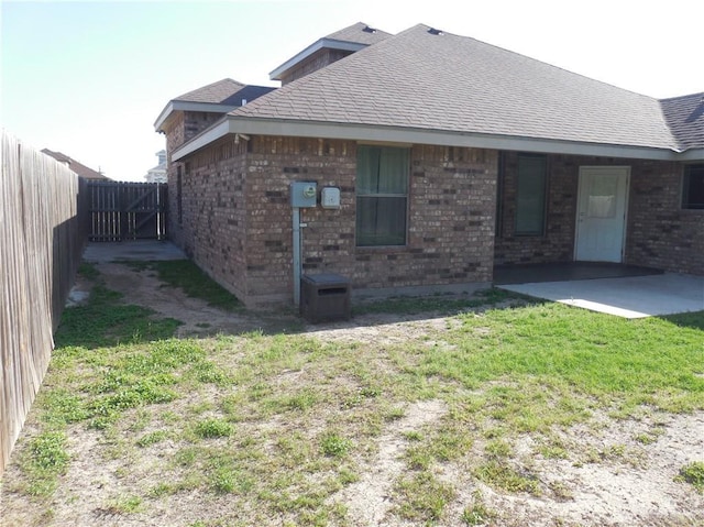 5421 San Diego Dr, Edinburg, TX 78542 - view of home's exterior with a shingled roof, brick siding, and a patio area