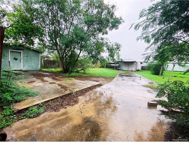 view of yard featuring an outdoor structure and fence