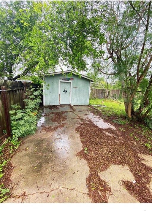 exterior space with a storage shed, a fenced backyard, and an outdoor structure