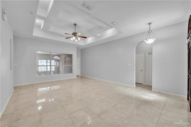 spare room featuring ceiling fan and a raised ceiling