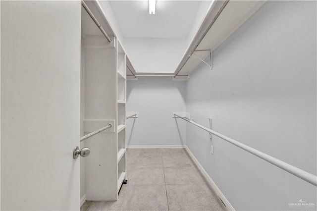 spacious closet with light tile patterned floors