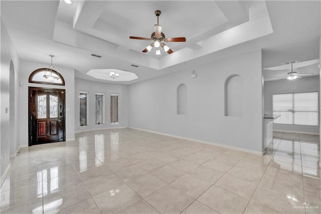 spare room featuring ceiling fan, a tray ceiling, and light tile patterned floors