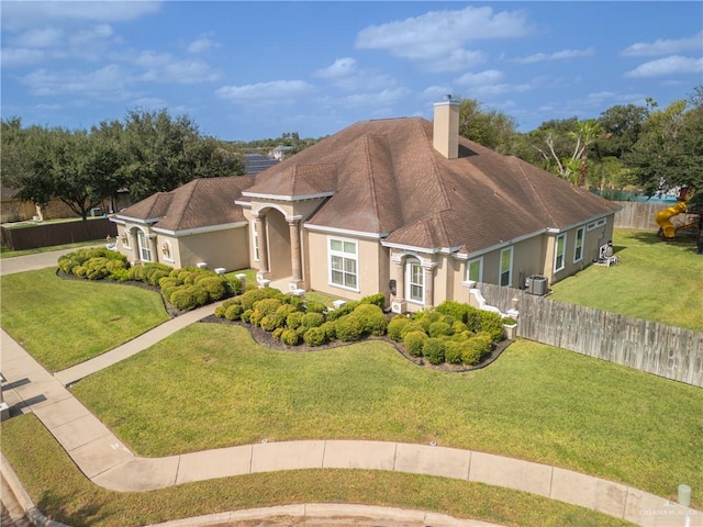 view of front of home with a front yard and central air condition unit