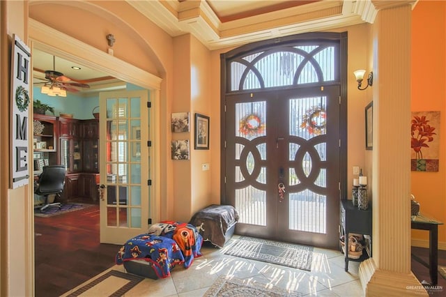 entrance foyer with light hardwood / wood-style floors, ornamental molding, and french doors