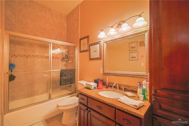 full bathroom featuring tile patterned floors, vanity, toilet, and enclosed tub / shower combo