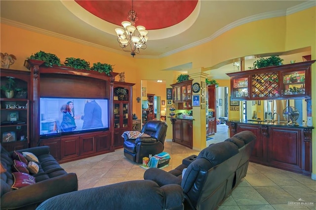 living room with light tile patterned floors, a tray ceiling, ornamental molding, and a notable chandelier