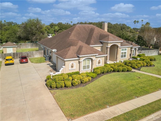 mediterranean / spanish home featuring a front yard and a garage