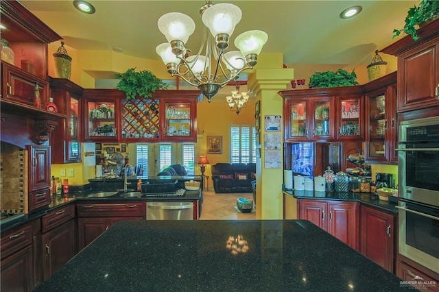 kitchen featuring stainless steel appliances, a chandelier, sink, and pendant lighting