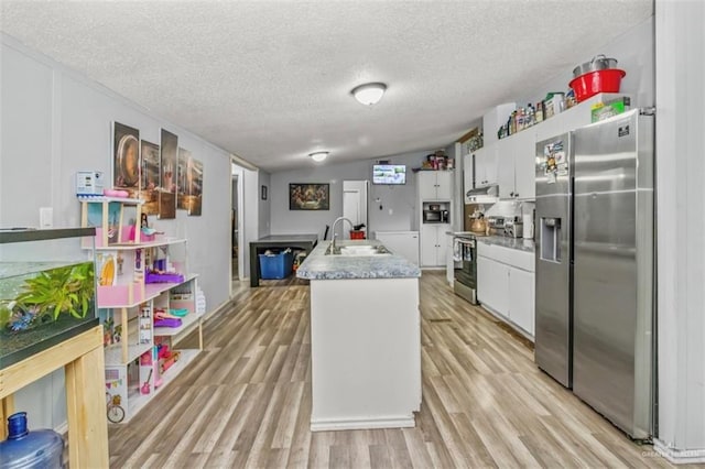 kitchen with sink, stainless steel appliances, light hardwood / wood-style flooring, a center island with sink, and white cabinets