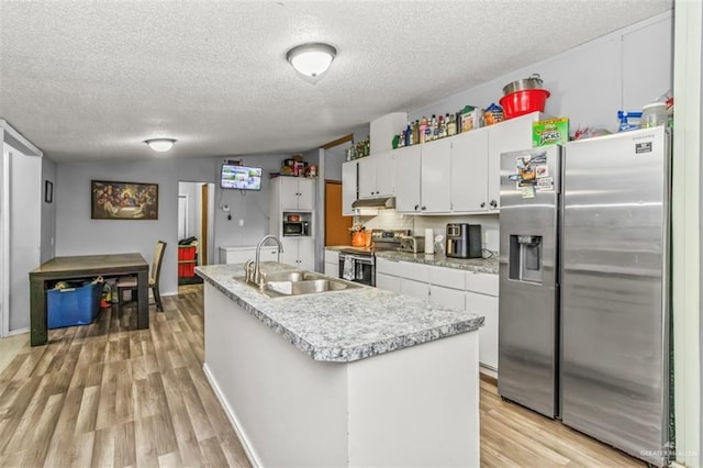 kitchen with white cabinets, light hardwood / wood-style flooring, a textured ceiling, an island with sink, and appliances with stainless steel finishes