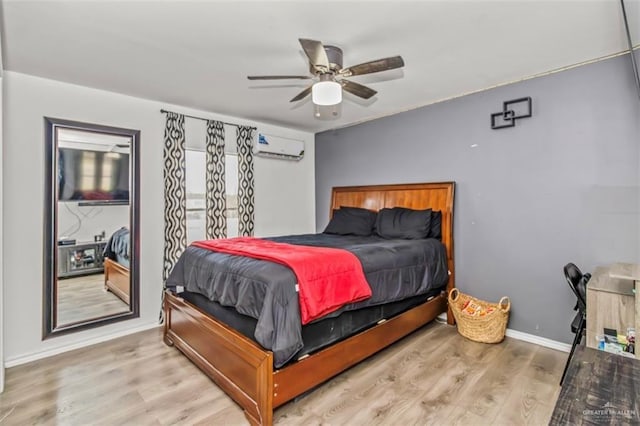 bedroom with a wall mounted air conditioner, ceiling fan, and light hardwood / wood-style floors