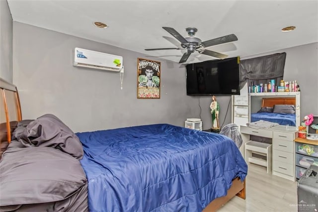 bedroom featuring a wall unit AC, ceiling fan, and light hardwood / wood-style floors