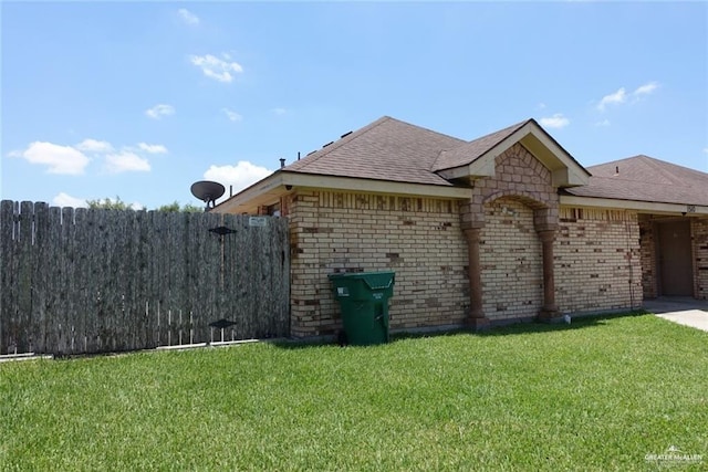 view of side of home with a lawn