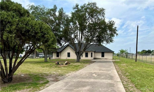 view of front of property with fence, a front lawn, and concrete driveway