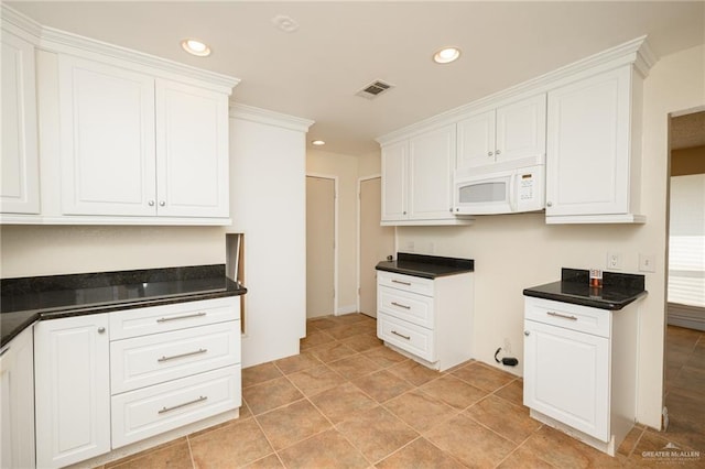 15220 Wilson Rd, Harlingen, TX 78552 - kitchen featuring white microwave, recessed lighting, dark countertops, and white cabinets
