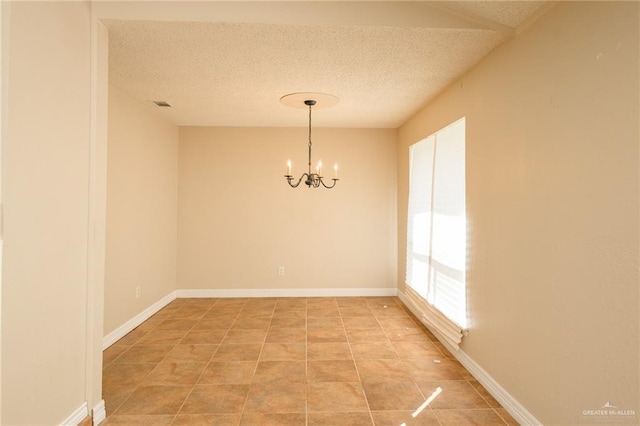 15220 Wilson Rd, Harlingen, TX 78552 - empty room with a chandelier, a textured ceiling, and light tile patterned floors