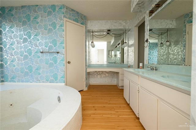 15220 Wilson Rd, Harlingen, TX 78552 - full bathroom with wallpapered walls, wood finished floors, double vanity, and a garden tub