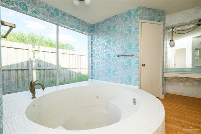 15220 Wilson Rd, Harlingen, TX 78552 - full bathroom with wallpapered walls, a tub with jets, and wood finished floors