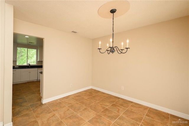 15220 Wilson Rd, Harlingen, TX 78552 - unfurnished room featuring a chandelier, light tile patterned floors, and a textured ceiling