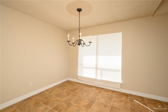 15220 Wilson Rd, Harlingen, TX 78552 - spare room featuring a chandelier, tile patterned flooring, and a textured ceiling