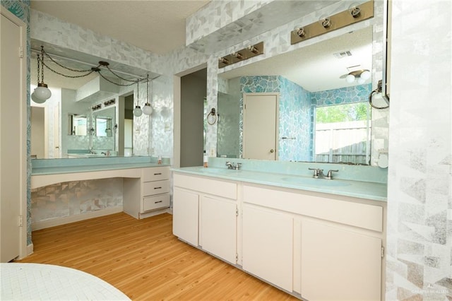 15220 Wilson Rd, Harlingen, TX 78552 - full bathroom featuring wallpapered walls, wood finished floors, and double vanity