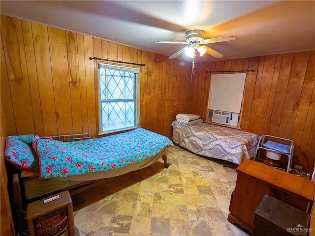 bedroom with wooden walls, cooling unit, a ceiling fan, and stone finish flooring