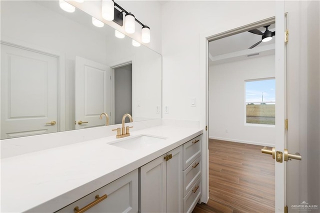 bathroom with hardwood / wood-style floors, ceiling fan, and vanity