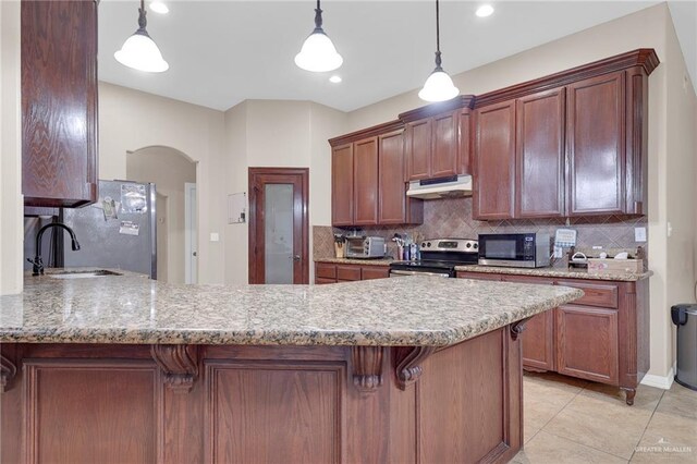 1617 N Monmack Rd, Edinburg, TX 78541 - kitchen with stainless steel appliances, under cabinet range hood, a peninsula, decorative backsplash, and arched walkways