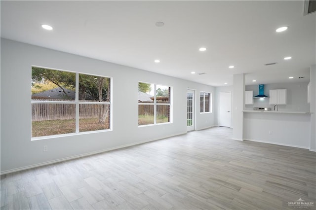 unfurnished living room featuring light wood-type flooring and plenty of natural light