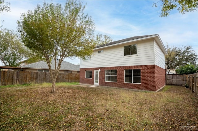 rear view of house featuring a lawn