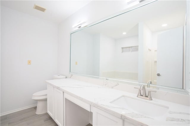 bathroom featuring hardwood / wood-style floors, vanity, and toilet