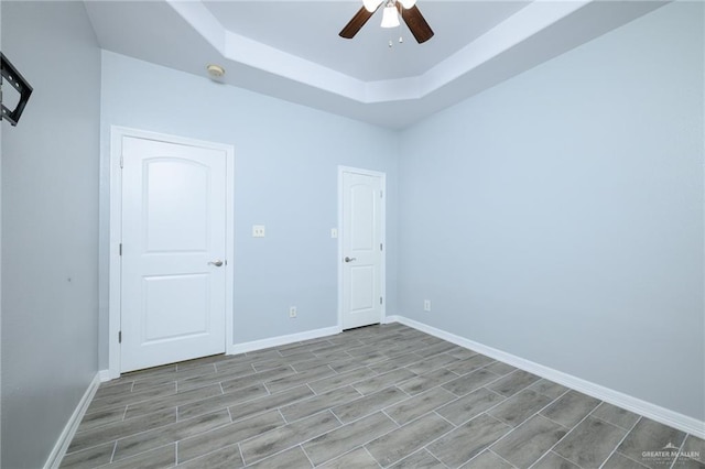 1710 Christian Cir, Harlingen, TX 78550 - unfurnished bedroom with a raised ceiling, wood finish floors, baseboards, and ceiling fan