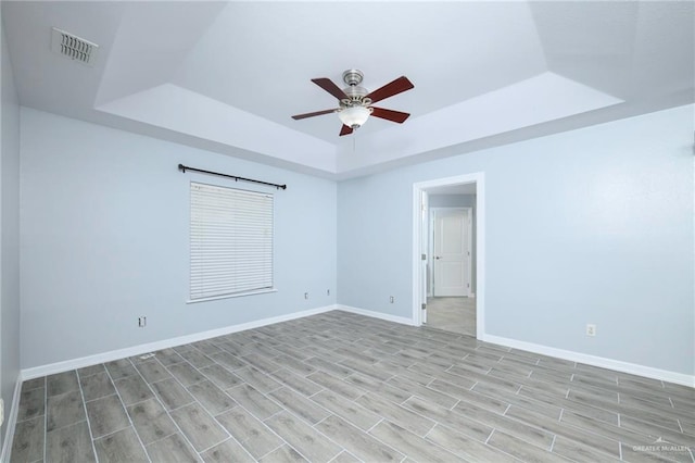 1710 Christian Cir, Harlingen, TX 78550 - unfurnished room with a tray ceiling, a ceiling fan, light wood-style floors, and baseboards