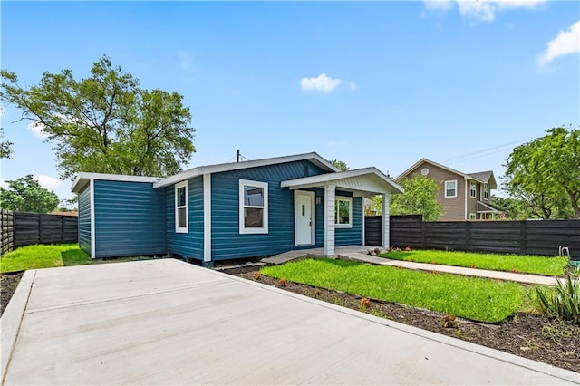 view of front of property with a porch, fence private yard, and a front lawn