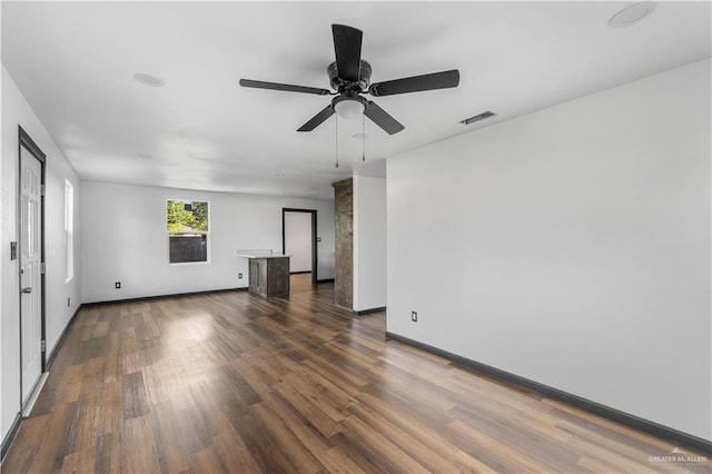 unfurnished living room featuring visible vents, a ceiling fan, dark wood finished floors, and baseboards