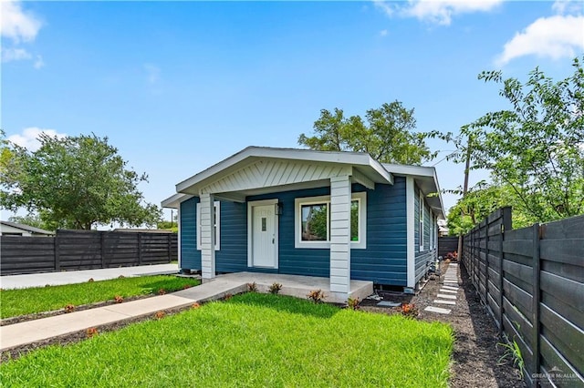 bungalow-style house with a fenced backyard, a porch, and a front lawn