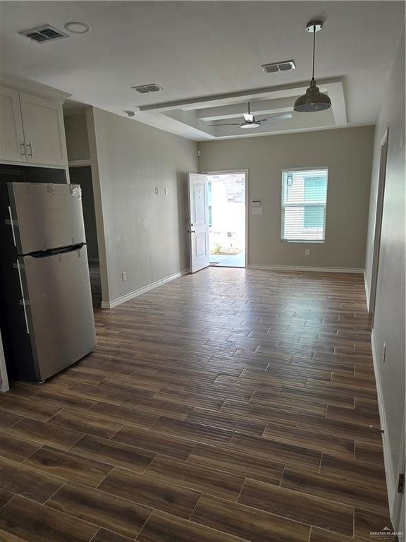 2604 Israel Ave, Alton, TX 78573 - kitchen featuring freestanding refrigerator, open floor plan, wood finish floors, baseboards, and white cabinets