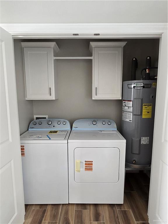 2604 Israel Ave, Alton, TX 78573 - laundry area with cabinet space, electric water heater, washer and clothes dryer, and dark wood-type flooring