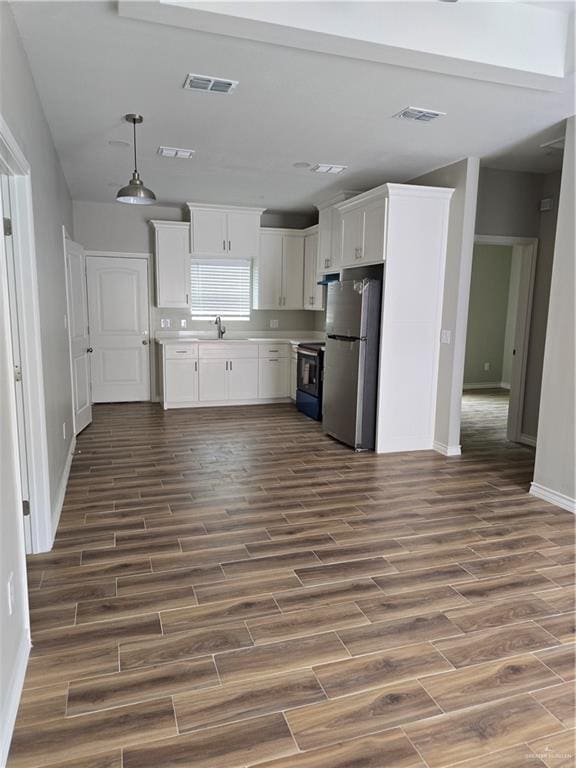 2604 Israel Ave, Alton, TX 78573 - kitchen featuring freestanding refrigerator, electric stove, dark wood-type flooring, baseboards, and white cabinetry