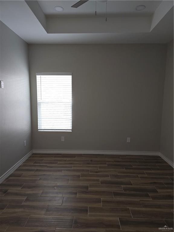 2604 Israel Ave, Alton, TX 78573 - spare room featuring dark wood-style floors, baseboards, a tray ceiling, and ceiling fan