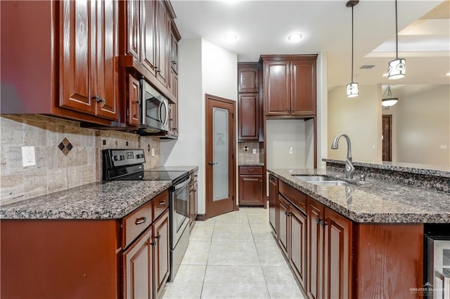 kitchen featuring light tile patterned flooring, pendant lighting, sink, dark stone countertops, and stainless steel appliances