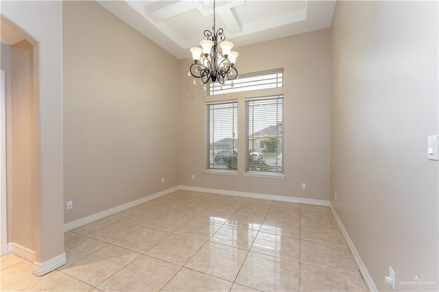 tiled empty room featuring beamed ceiling, coffered ceiling, and a chandelier