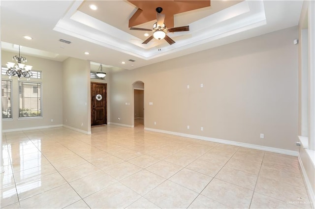 spare room with light tile patterned floors, a tray ceiling, and ceiling fan with notable chandelier