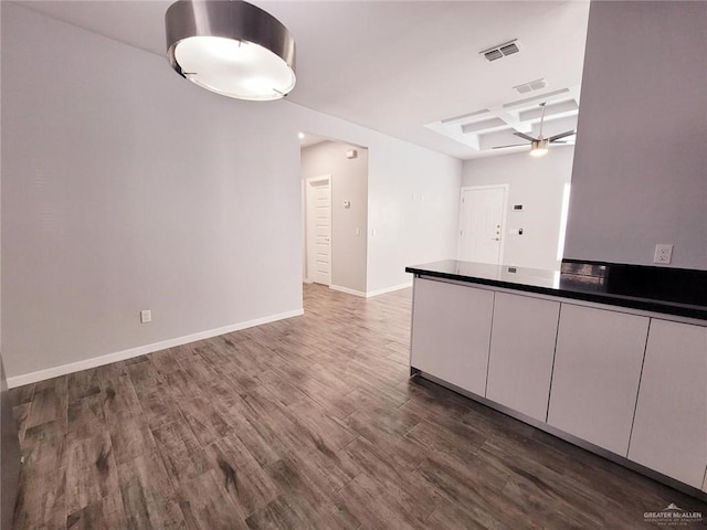 kitchen featuring white cabinetry, ceiling fan, dark hardwood / wood-style floors, coffered ceiling, and beam ceiling