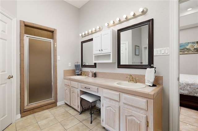 bathroom featuring tile patterned flooring, vanity, and walk in shower