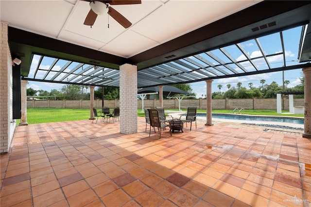 view of patio featuring glass enclosure, ceiling fan, and a fenced in pool